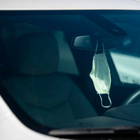 Mask hanging from car mirror