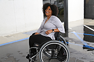 an African American woman in a wheelchair posing for the camera, smiling