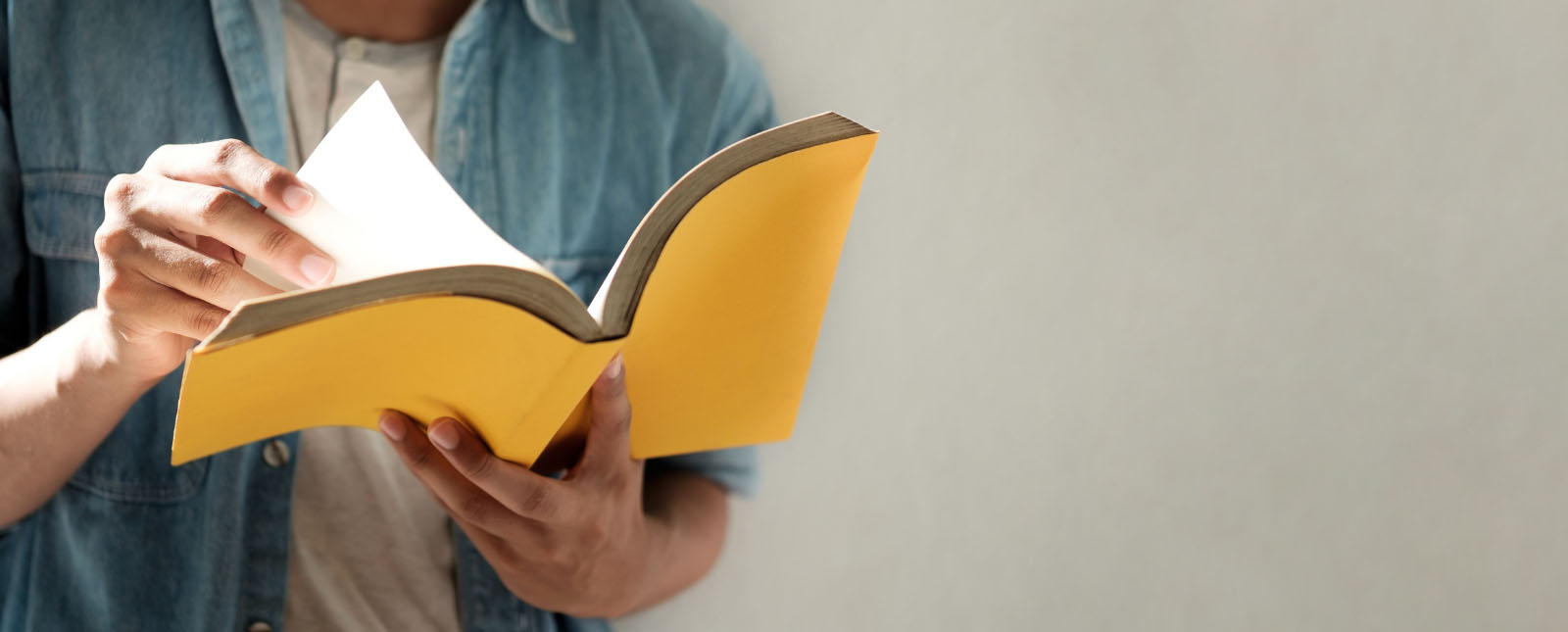 Picture of hands holding a yellow booklet